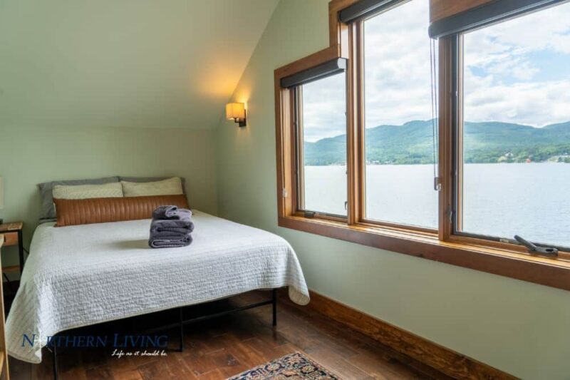Guest bed and windows overlooking Lake George at French Mountain Cove vacation home rental