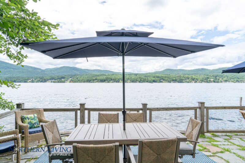 Patio dining set and umbrella on patio overlooking Lake George at French Mountain Cove vacation home rental on Lake George