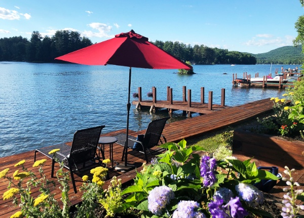 Dockside Manor dock with two chairs and a red umbrella