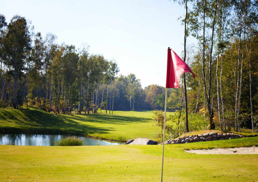 golf course with sunlight hitting flag in autumn