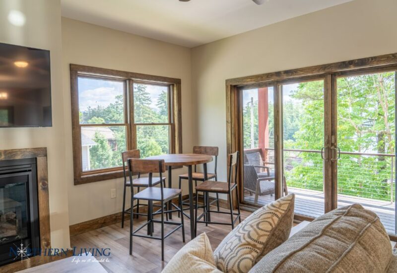 High top table and chairs next to glass doors out to the deck