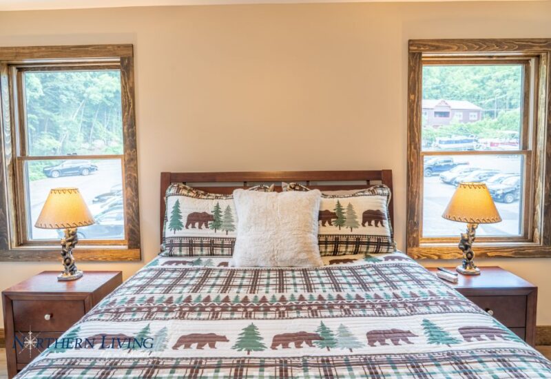 bed with two nightstands and windows on either rside