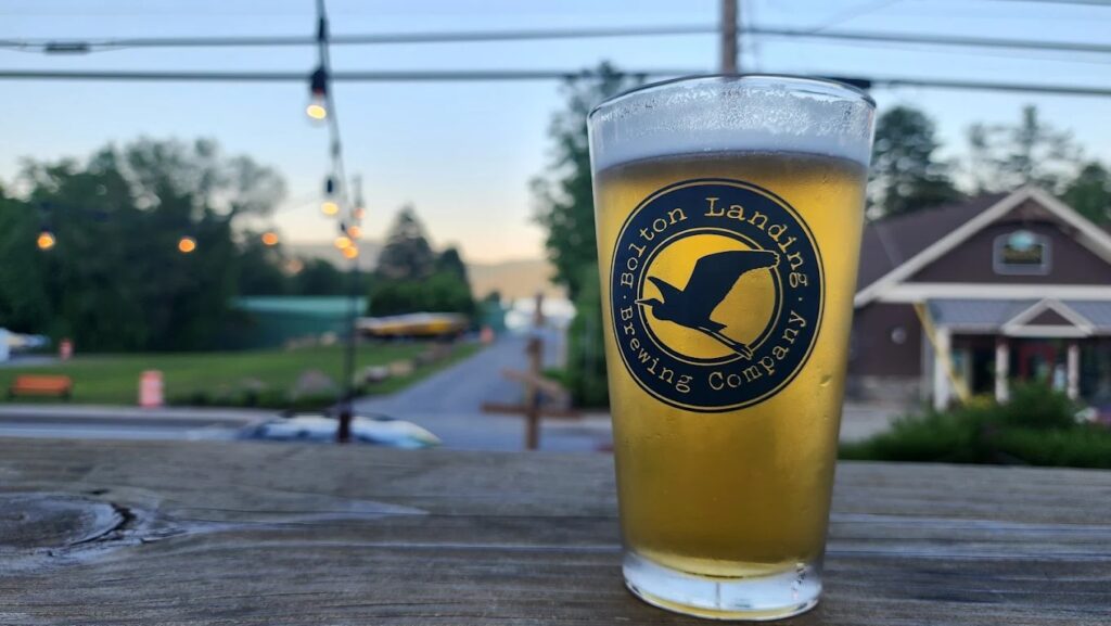 Bolton Landing Brewing Company pint glass with beer overlooking Lake George