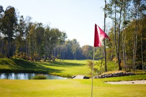 golf course with sunlight hitting flag in autumn