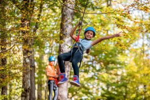 Girl on zipline in aerial adventure park
